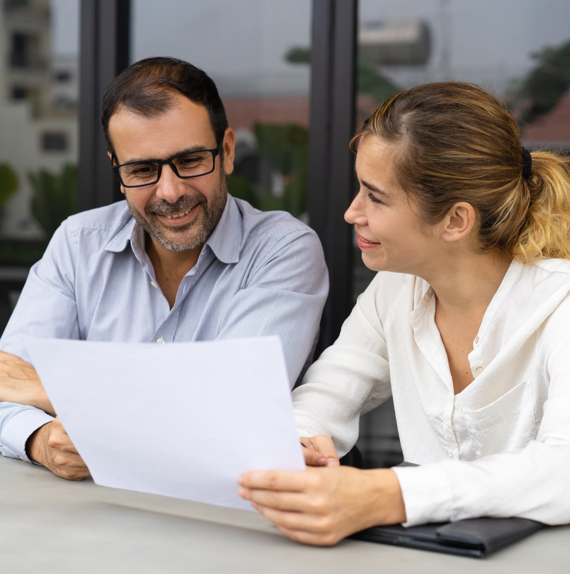 Man and woman meeting outside, reviewing a piece of paper